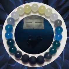 an image of a bracelet made out of glass beads and marbles on a blue background