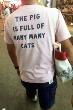 a man wearing a t - shirt that says the pig is full of many many cats