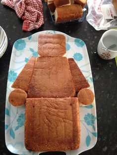 a cake shaped like a man sitting on top of a plate next to other food