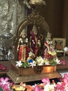 an idol is displayed on a table with flowers