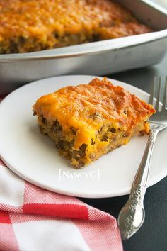 a piece of meat and cheese casserole on a white plate with a fork