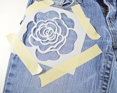 a cut out flower on the back of a pair of jeans with tape around it