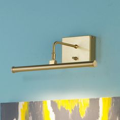 a wall mounted light on the side of a blue wall with yellow and white paint