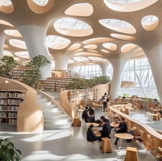 people are sitting at tables and reading books in a large room with high ceilinged ceilings