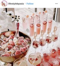 a table topped with lots of glasses filled with pink liquid