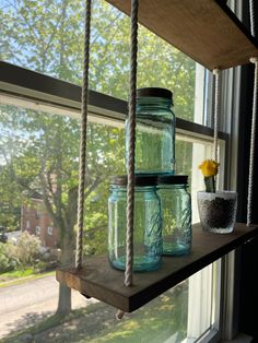 mason jars are hanging from a window sill