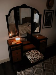 a leopard print ottoman sits in front of a dressing table with a mirror and stool