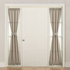 an open door with curtains hanging on the side