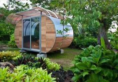 a small wooden structure surrounded by plants and trees