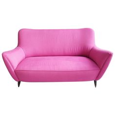 a pink couch sitting on top of a white floor