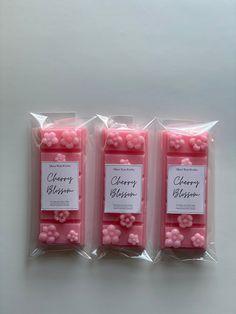 three bags filled with pink candies sitting on top of a table