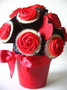 cupcakes are arranged in a red flower pot