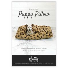 a dog laying on top of a bed covered in a blanket with paw prints and the words puppy pillow