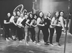 a group of women standing next to each other in front of a microphone on top of a hard wood floor