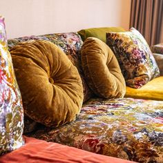 the couch is covered with many colorful pillows