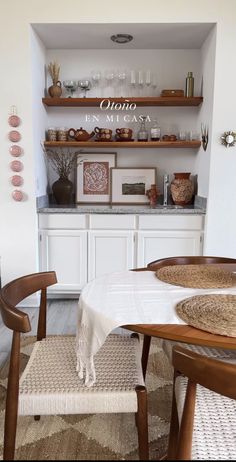 a dining room table with two chairs and some shelves