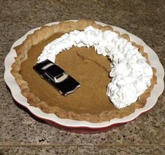 a pie with whipped cream and a car on top