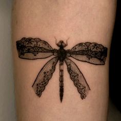 a black and white photo of a dragonfly tattoo