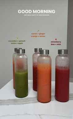 three bottles with different colored liquids on top of a white counter next to each other