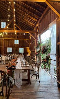 the inside of a barn with tables and chairs set up for a formal dinner or party