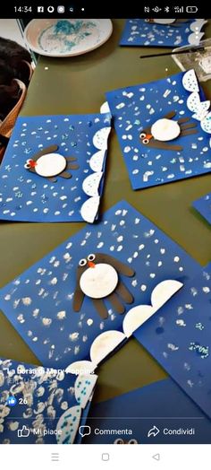 some cards are sitting on a table with plates and cups in the shape of penguins