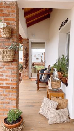 the porch is decorated with plants and wicker baskets