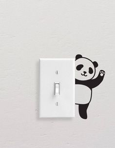 a light switch with a panda bear sticker on it's side and a white wall