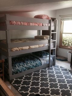 a room with bunk beds in it and a rug on the floor