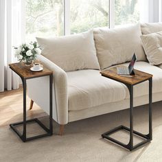 a white couch sitting next to a wooden table on top of a rug covered floor