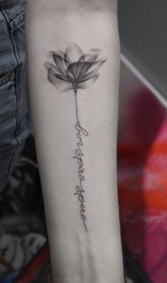 a woman's arm with a flower tattoo on it