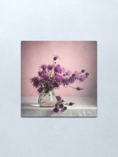 a vase filled with purple flowers sitting on top of a table canvas wall art print