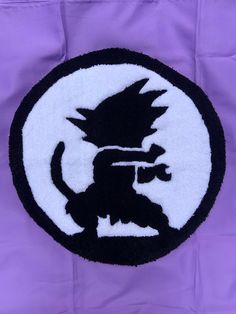 a black and white patch with a cat on it's back in front of a purple background