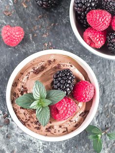 two bowls filled with chocolate mousse and raspberries on top of each other