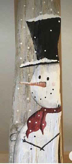 a snowman painted on a piece of wood