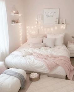 a white bedroom with pink and grey decor on the walls, lights strung up above the bed