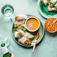 two plates with food on them and some dipping sauces