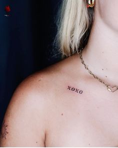 a woman with a tattoo on her chest saying xoxo in front of her