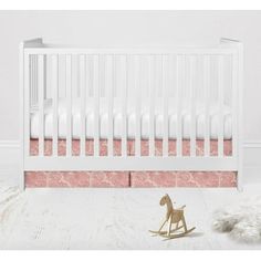 a white crib with pink wallpaper and a toy horse on the floor next to it