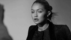 black and white photo of woman with ponytail in front of mirror looking at man's face