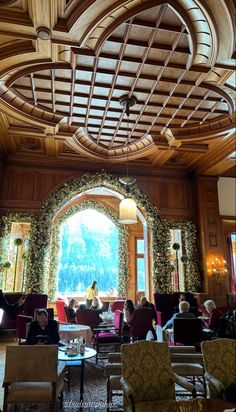 people are sitting in chairs and looking out the window at an outside area with wood paneling