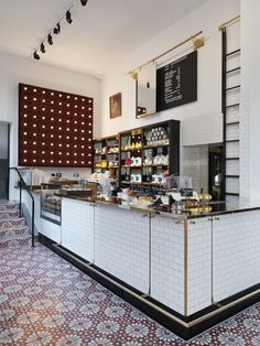 the interior of a restaurant with white brick walls and red patterned flooring on the ground