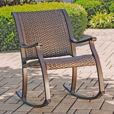 a brown rocking chair sitting on top of a brick patio