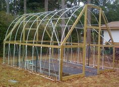 a large green house sitting in the middle of a yard