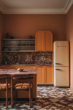 a kitchen with an old fashioned refrigerator and table in the center, next to it is a tiled floor