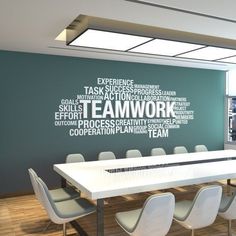 a conference room with a large table and chairs in front of a wall that has words written on it