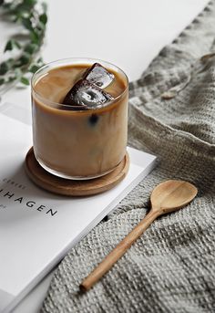 there is a drink on the table next to a spoon and napkin with an ice cream in it