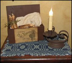 a candle is sitting on a table next to an old box and some other items