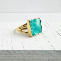 Turquoise Ring | Gold and Silver | Square Gemstone Ring | Triple Band | Statement Ring | Adjustable Ring | Gift for Her Elevate your look with our statement ring, featuring a square-shaped turquoise and a triple band. * Turquoise * Gold/Silver plated brass * Adjustable . . . . . . . . . . . . . . . .   💎 MATERIALS We use high quality chains, stones and materials. If you have any questions about stone or component colors, please don't hesitate to contact us. . . . . . . . . . . . . . . . . . . . . . . . . . . . . . . . . .  📦 PRODUCTION & SHIPPING All pieces are made by Tracy in her studio in sunny Northern California, so please allow 2-3 days before your order is ready to be shipped. Keep in mind that production time does not include shipping time.  Shipping time depends on the shipping Turquoise Ring Gold, Ring Gold And Silver, Triple Band Ring, Turquoise Gold Ring, Gold Gemstone Ring, Ringe Gold, Gems Jewelry, Jewelry Case, Ring Gold