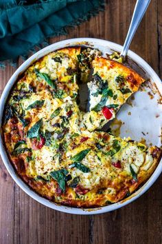 a close up of a pizza in a pan on a wooden table with a slice missing