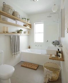 a white bathroom with open shelving above the bathtub